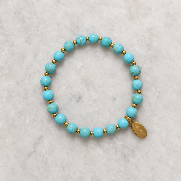 Pulsera de Howlita Azul Esencia Pulsera de Howlita Azul Esencia con detalles dorados de acero inoxidable