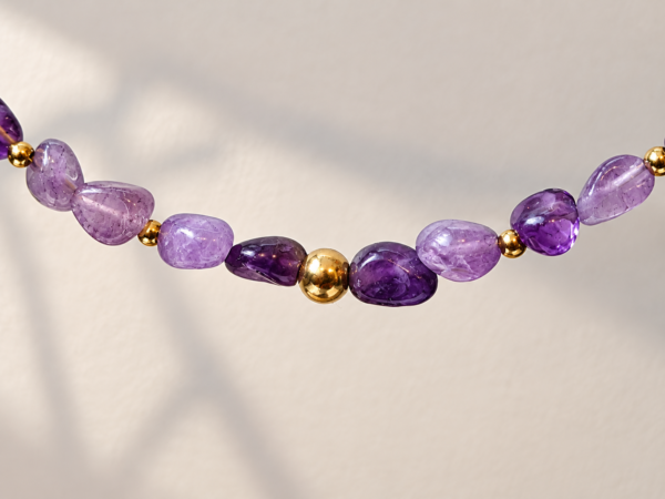 Acercamiento de collar de amatista natural Violeta con detalles dorados de acero inoxidable